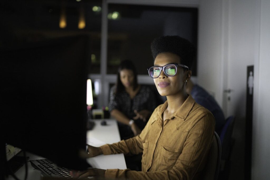 Una chica está sentada frente a la computadora con una postura correcta