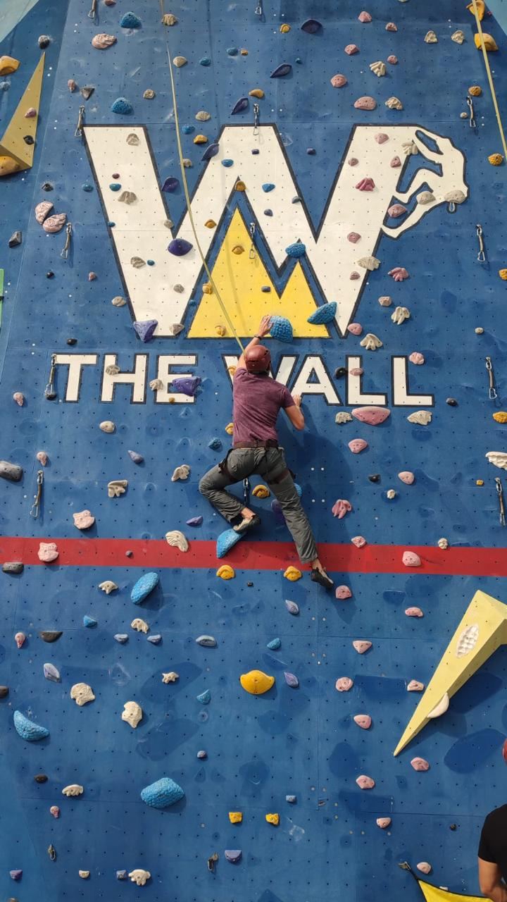 Escalando en un muro, de espaldas