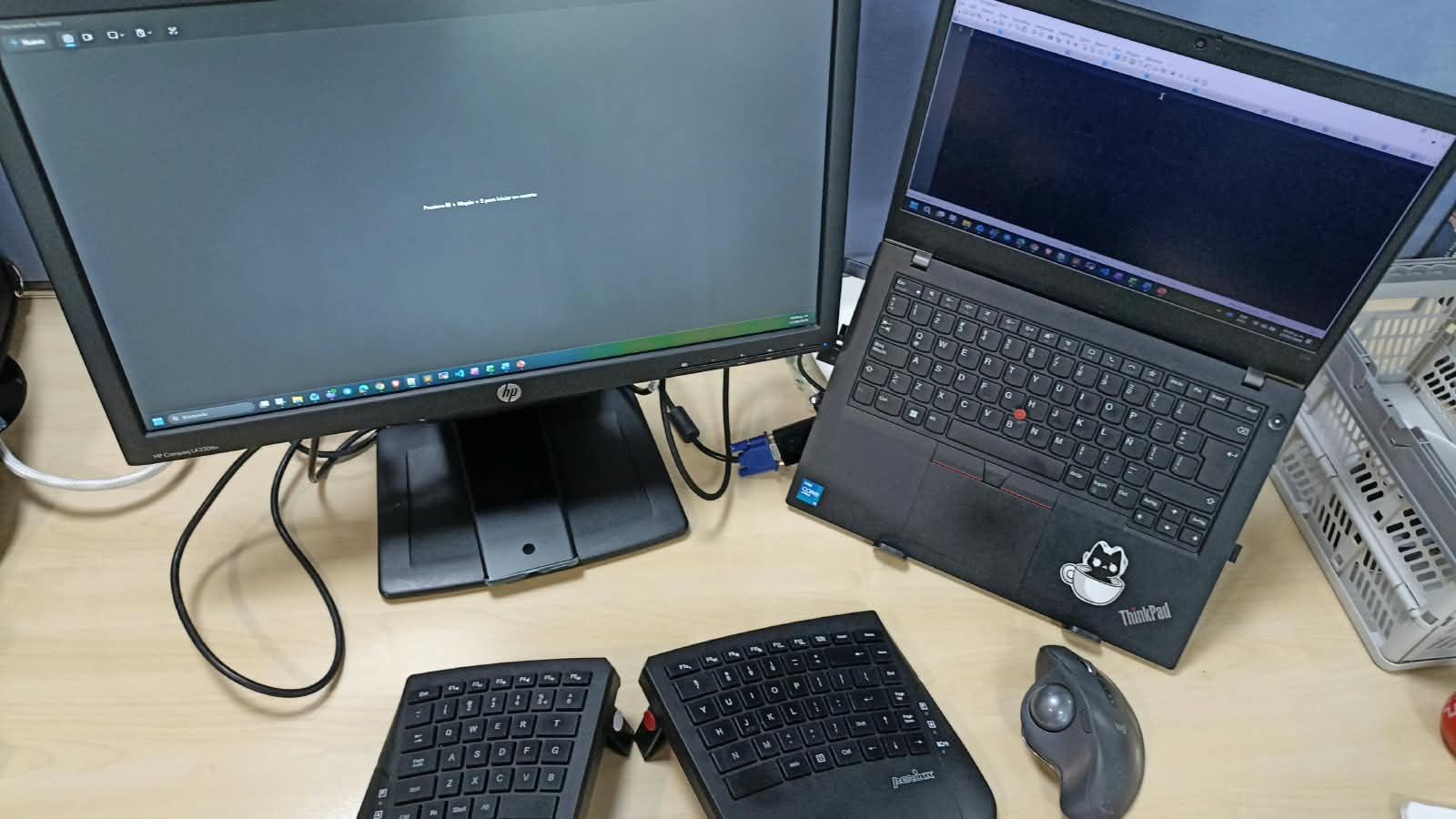 Escritorio con doble pantalla, teclado dividido y trackball